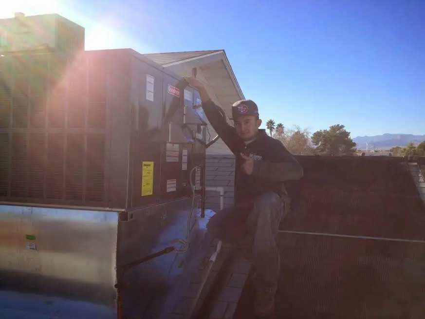 HVAC technician performing Air Duct Cleaning on a rooftop unit in Salem Lakes